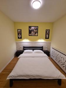 um quarto com uma cama grande e lençóis brancos em Zen Apartment em Sighetu Marmaţiei
