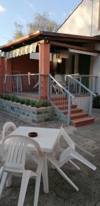 パリヌーロにあるCasa Vacanze Mimoseの白い椅子2脚と家の前のテーブル