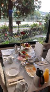a table with plates of food and a view of the water at Hotel Gonzlay in Traben-Trarbach