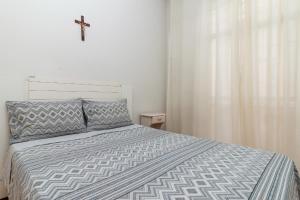 1 dormitorio con 1 cama con una cruz en la pared en Copacabana Apartamento - Ouro, en Río de Janeiro