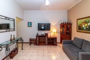 ein Wohnzimmer mit einem Sofa und einem TV in der Unterkunft Copacabana Apartamento - Ouro in Rio de Janeiro