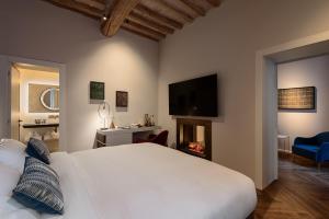 a bedroom with a large white bed and a fireplace at Times Suites & Bar in Perugia