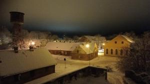 a village covered in snow at night with lights at Amanda's apartment in Kuldīga