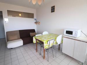 a small room with a table and a bed and a microwave at Appartement Le Grau-du-Roi, 2 pièces, 4 personnes - FR-1-307-11 in Le Grau-du-Roi