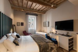 a bedroom with a large bed with a television and a tub at Times Suites & Bar in Perugia