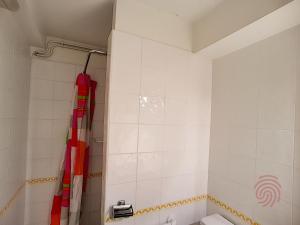 uma casa de banho com um chuveiro e uma cortina de chuveiro vermelha. em Appartement Lamalou-les-Bains, 2 pièces, 2 personnes - FR-1-451-24 em Lamalou-les-Bains