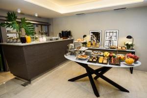 SuMa Recoleta Hotel في بوينس آيرس: طابور بوفيه مع طاولة عليها طعام