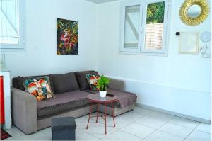 a living room with a couch and a table at Résidence Flores De Maria in Le Marin