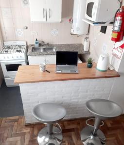 a kitchen with a laptop on a counter with two stools at Mar de Anto in Puerto Madryn
