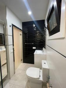 y baño blanco con aseo y ducha. en Happy Space Apartment en Los Cristianos