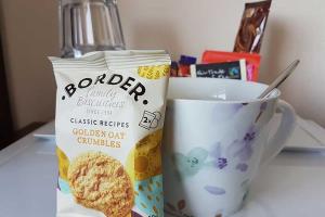 a bag of cookies next to a cup of coffee at The Coast Yard B & B and Garden Chalets in Chichester