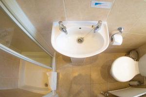 a bathroom with a white sink and a mirror at The Coast Yard B & B and Garden Chalets in Chichester