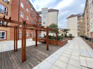 a patio with a wooden pergola in a building at Moroccan Inspired Northampton Apartment in Northampton