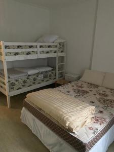a bedroom with a bed and two bunk beds at Apartamento frente Mar Santos in Santos