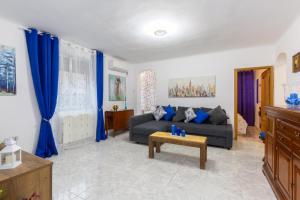 - un salon avec des rideaux bleus et un canapé dans l'établissement Apartamento Casa de Campo, à Madrid