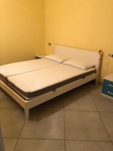 Ce lit se trouve dans un dortoir doté de draps blancs. dans l'établissement casa Olivieri, à Carisolo