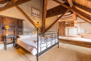a bedroom with a metal bed in a attic at Luxury Chalet with outdoor Hot Tub, Sauna, Gardens & Mountain Views! in Briançon
