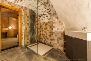 a bathroom with a glass shower and a sink at Luxury Chalet with outdoor Hot Tub, Sauna, Gardens & Mountain Views! in Briançon