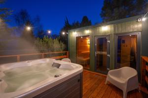 una vasca da bagno situata sulla parte superiore di una terrazza in legno di Izera Glamping Adults - Luksusowe jurty&spa (adults only) a Gajowka