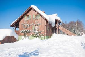 een huis bedekt met sneeuw ervoor bij Kocurzonka Apartamenty in Jaworzynka