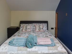 a bed with clothes and towels on it at Moorhens in Herstmonceux