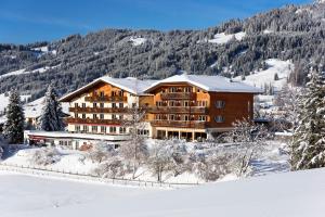 un hôtel dans les montagnes avec de la neige au sol dans l'établissement Hotel Hohenfels, à Tannheim