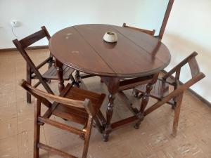 Temporario Salta في سالتا: طاولة خشبية عليها كرسيين و فأر كمبيوتر
