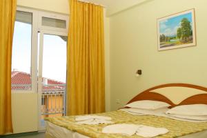 a bedroom with a bed and a window with a view at Hotel Panorama in Sveti Vlas