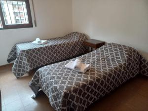 two beds in a hotel room with towels on them at Temporario Salta in Salta