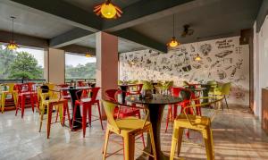 a restaurant with red and yellow chairs and tables at Treebo Trend Three Street Inn in Bangalore