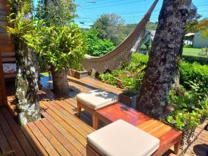 uma rede num deque com árvores e plantas em Casas Ana em Canela