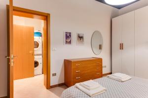 1 dormitorio con 1 cama, vestidor y lavadora en RomagnaBNB La Scranna, en Forlì