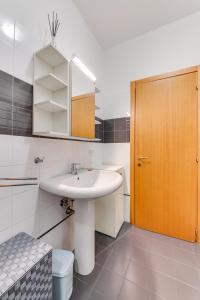 Łazienka z umywalką i drewnianymi drzwiami w obiekcie RomagnaBNB La Scranna w Forli