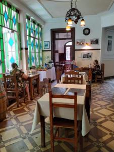 un restaurante con mesas y vidrieras. en Posada Chalet de Bassi en Mendoza