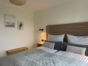 a bedroom with a bed and a wooden headboard at Ferienwohnung Watt'n Weitblick in Simonsberg