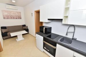 a small kitchen with a sink and a microwave at Apartment Sana 1 in Vir +4 photos
