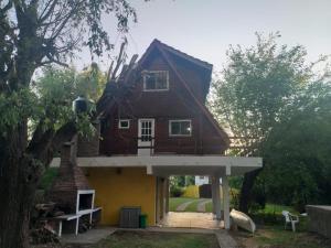 una casa con techo y porche blanco en LA ALPINA en Dique Luján