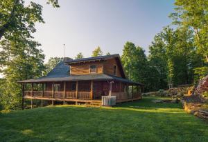 a large log cabin with a porch on a lawn at A Touch of Luxury in Lake Lure