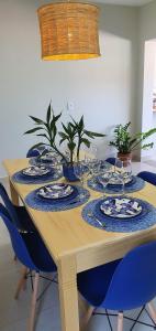 a wooden table with plates and wine glasses on it at Casa Romão I - Charme perto de Vinícola e Centro in Espirito Santo Do Pinhal