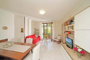 a living room with a table and a red couch at Villetta Quiete - Gardagate in Padenghe sul Garda