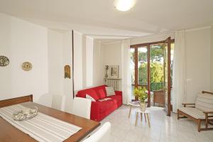 salon z czerwoną kanapą i stołem w obiekcie Villetta Quiete - Gardagate w mieście Padenghe sul Garda