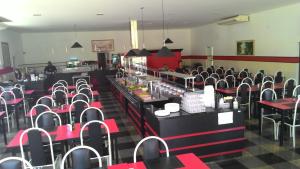 a restaurant with red and black tables and chairs at Pekin Palace Hotel in Araçatuba