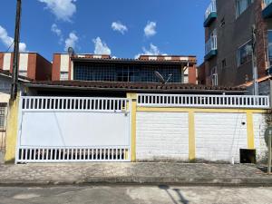 uma porta de garagem branca com acabamento amarelo num edifício em Casa da Si Hostel em Ubatuba