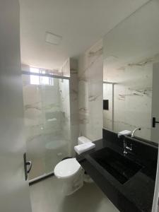 y baño con aseo, lavabo y ducha. en Apartamento vista mar em João Pessoa, en João Pessoa