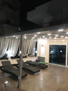 un grupo de sillones en una habitación con cortinas blancas en Pirro Luxury Apartment, en Sarandë