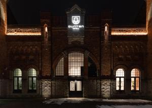 un edificio de ladrillo con un letrero iluminado en Dunten Hotel, en Tallin