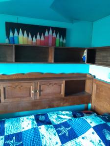 Un dormitorio con una cama con una pared azul y estanterías en chambre d'hôtes de Flo, en Brosses