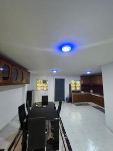 a room with a table and chairs and a kitchen at Yushas Homestay in Tawau
