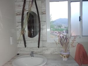 a bathroom with a sink and a window and a mirror at VILLA DE MONTAÑA LOS CHACAYES, Manzano Histórico, Tunuyán in Tunuyán