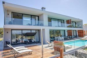 a house with a swimming pool and a villa at Hilltop Bayview Luxury Apartments in Plettenberg Bay